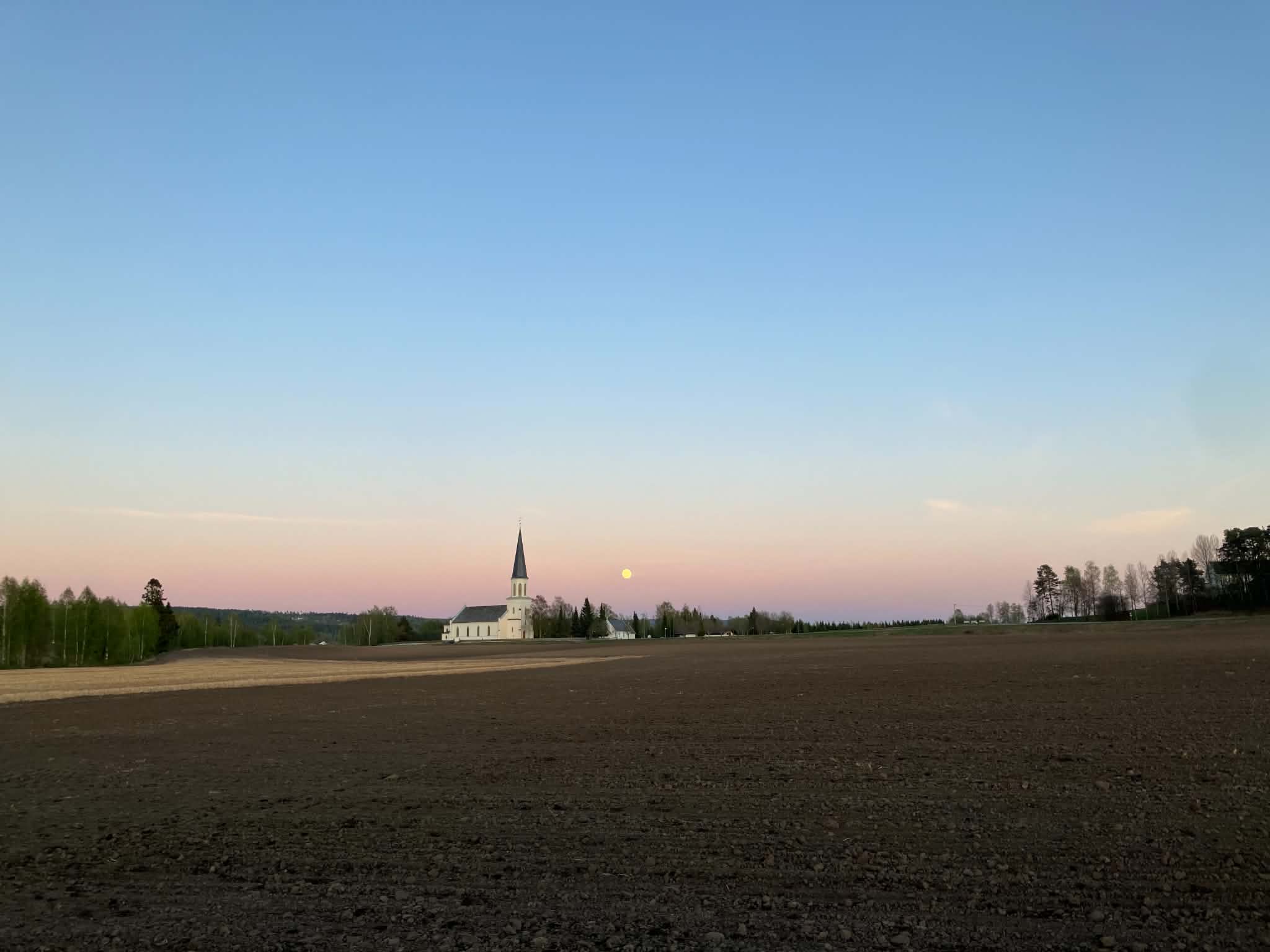 Norwegian farmland and a country church at dusk